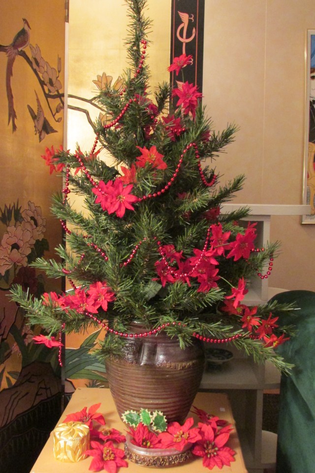 A table top tree in the corner of the living room.