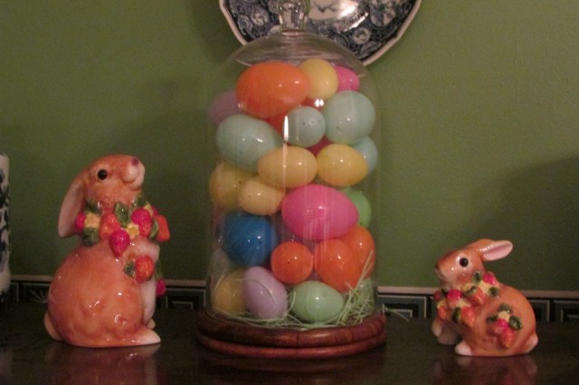Arranging Easter Eggs and other things under a glass dome.